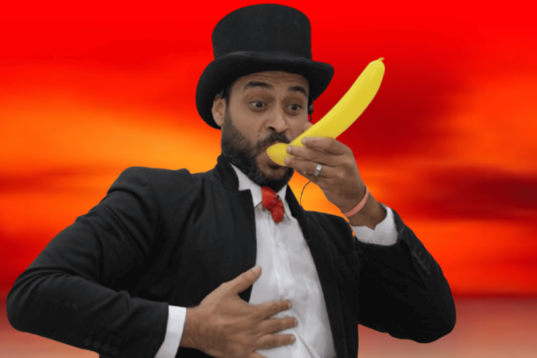 Mágico de cartola sorrindo nos bastidores, brincando com um balão em formato de banana